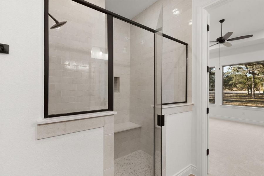 Bathroom with a shower stall, ceiling fan, and carpet