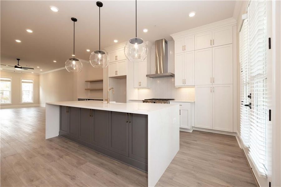 Upgrades are displayed throughout the home and especially in the Kitchen space.  Large glass pendant lighting, stunning staked white cabinets, GE Cafe series stainless steel range with 6 burners and chimney range hood.  Oversized island with White Porcel