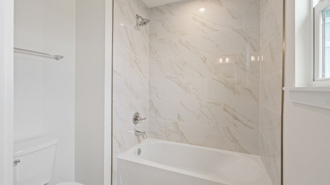 The Sweetgum secondary bathroom with dual sinks upstairs in Trailside at Mount Dora by DRB Homes