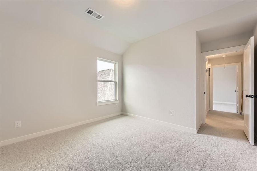 Unfurnished room with carpet floors, baseboards, and vaulted ceiling