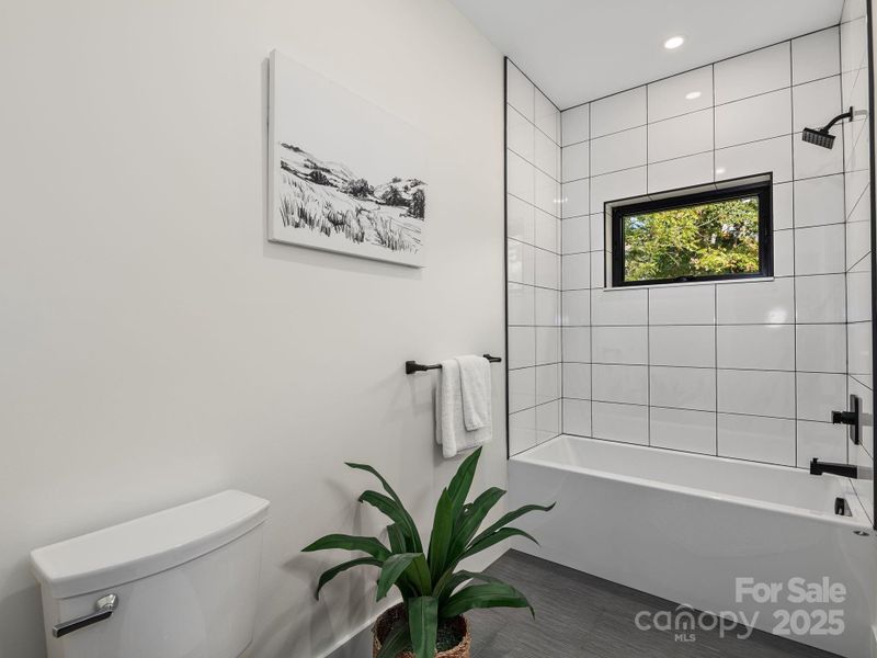 Bright and spacious bathroom complete with tiled flooring and shower surround
