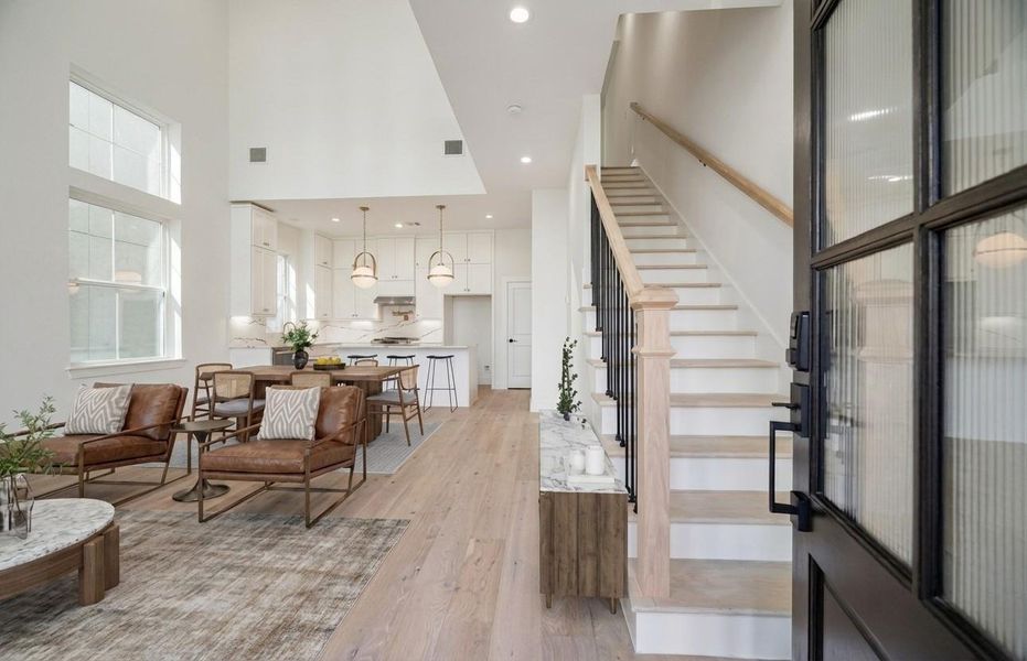 The view of the your living dining and kitchen area as you enter your home. This floor plan has soaring ceilings and windows all the way up. Tons of light in this beautiful home.