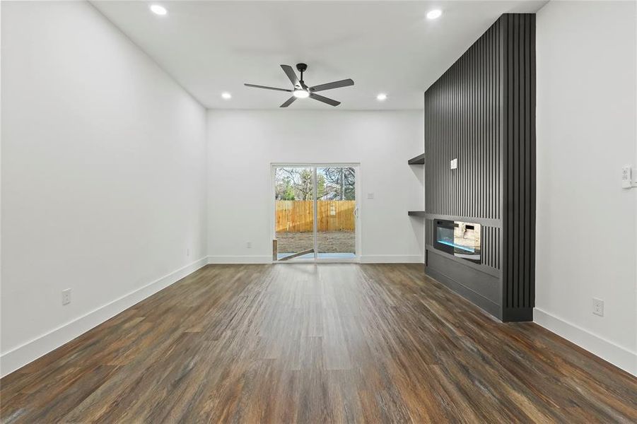 Unfurnished living room featuring dark wood-style flooring, recessed lighting, and a ceiling fan