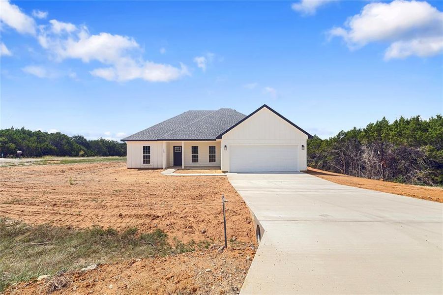 Ranch-style house with concrete driveway, an attached garage, and roof with shingles