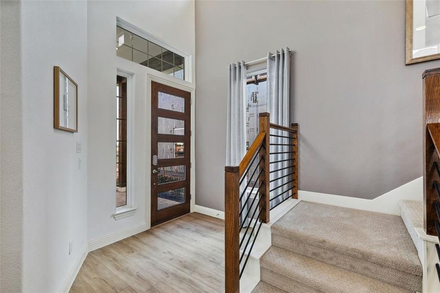 Entryway featuring a dark wood-finish door with frosted glass panels, surrounded by sidelight and transom windows
