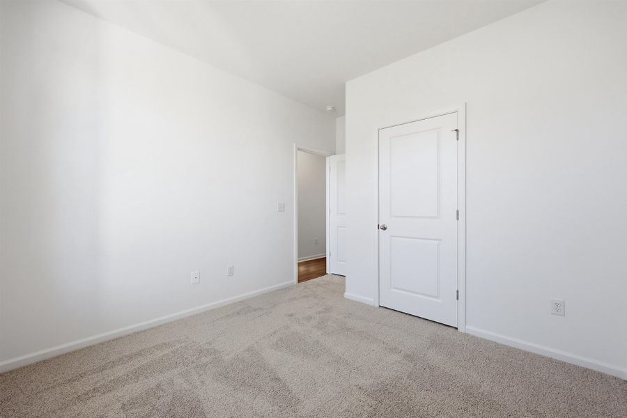 Unfurnished bedroom with carpet and baseboards