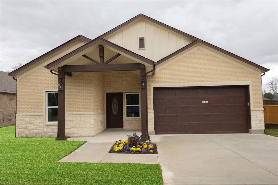 View of front of property featuring covered porch, concrete driveway, and stone siding View of front of property featuring covered porch, concrete driveway, and stone siding