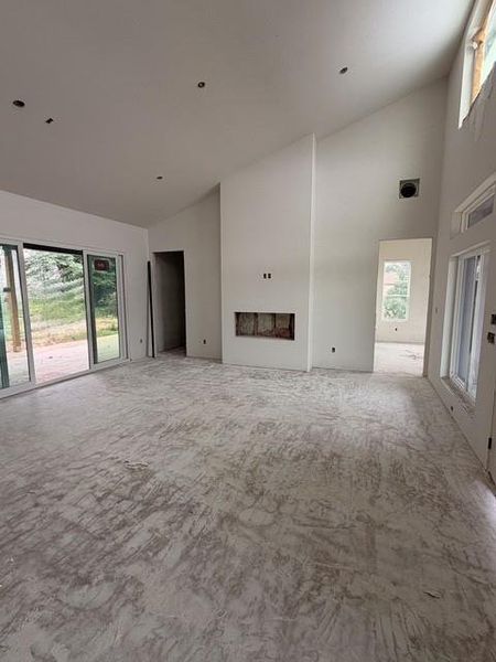 Spacious interior featuring high vaulted ceilings, recessed lighting, and an integrated fireplace