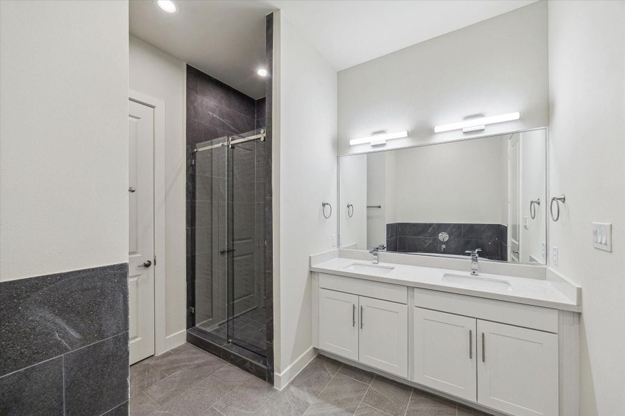 A double vanity with a crisp white quartz countertop and modern lighting offers a clean, sophisticated space for your morning routine.