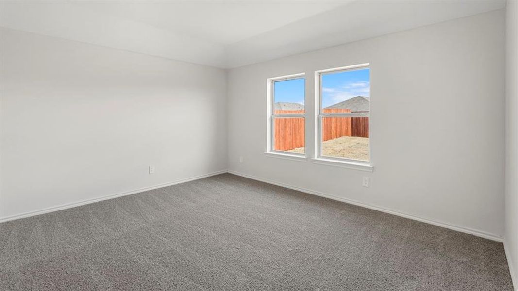 Spacious room featuring neutral carpeting, light-toned wall finishes, and two windows providing abundant natural light