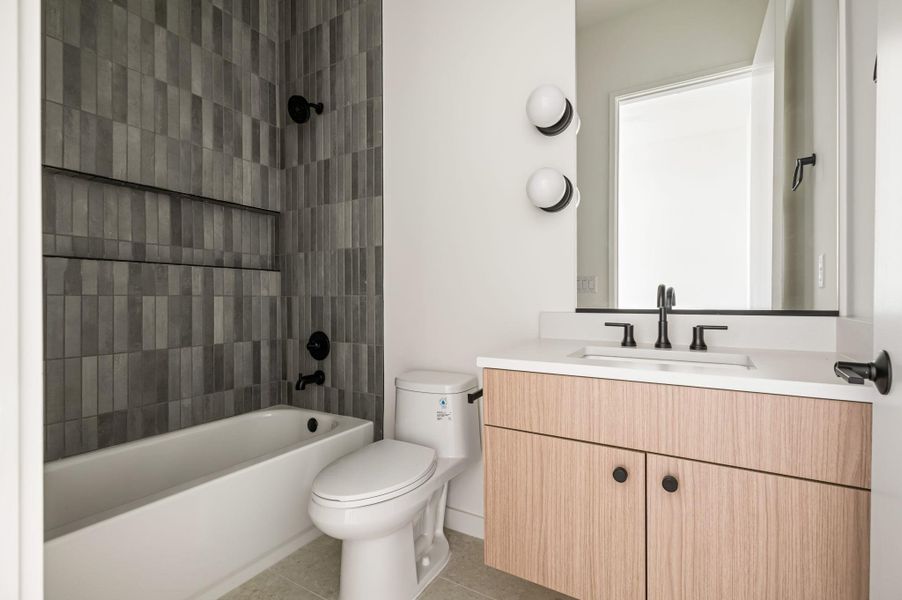Modern vertical tiling and light wood cabinetry highlight this sleek contemporary washroom.