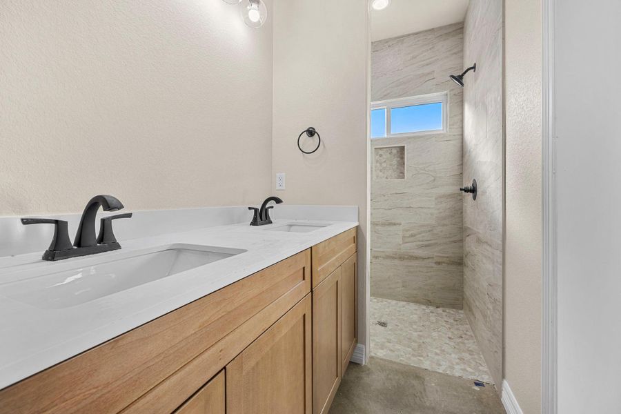 Bathroom with a tile shower and double vanity