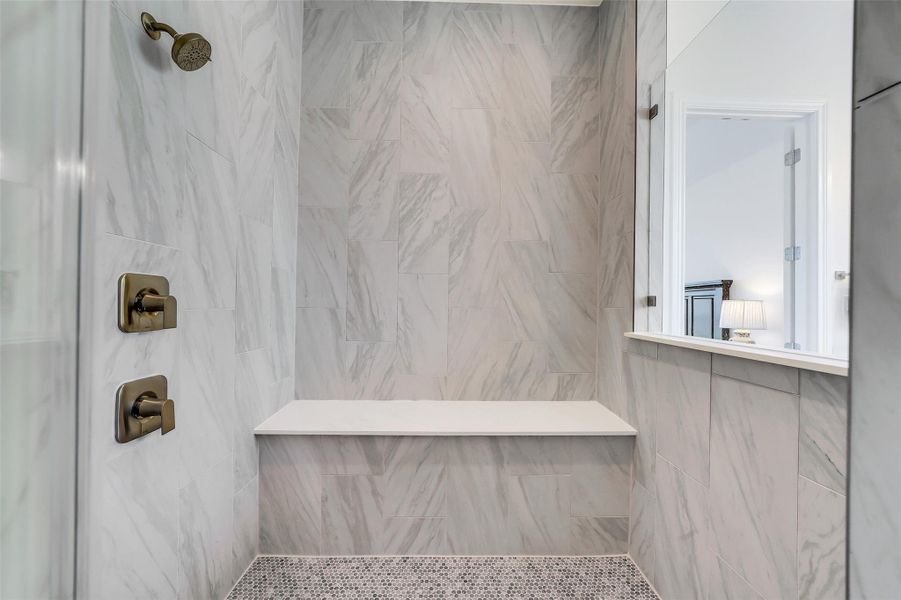 Primary shower with bench.