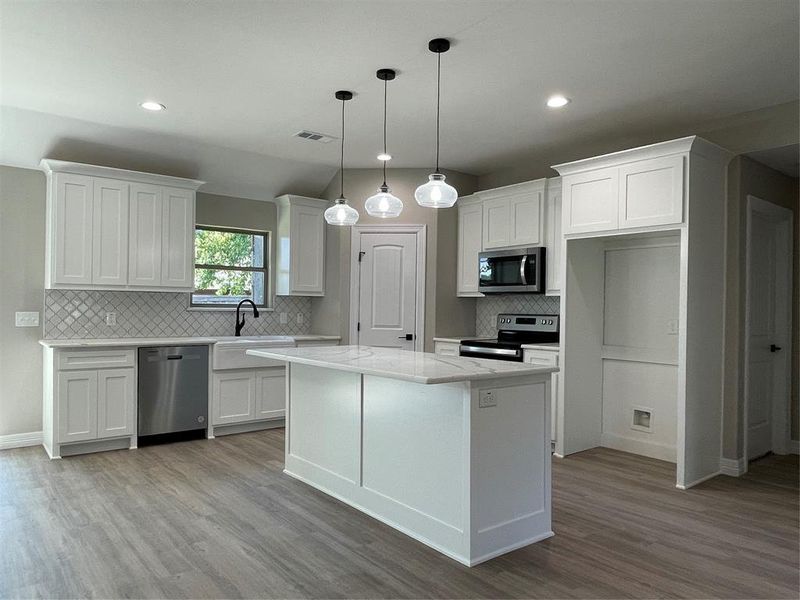 Kitchen featuring decorative backsplash, dishwashing machine, white cabinets, light hardwood / wood-style floors, and range