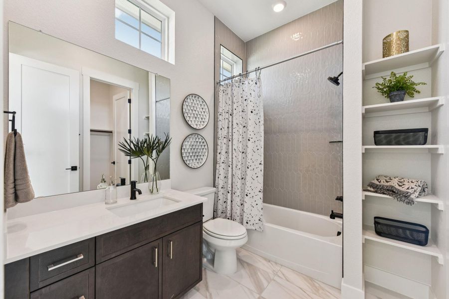 Bathroom with vanity, shower / tub combo with curtain, and a closet