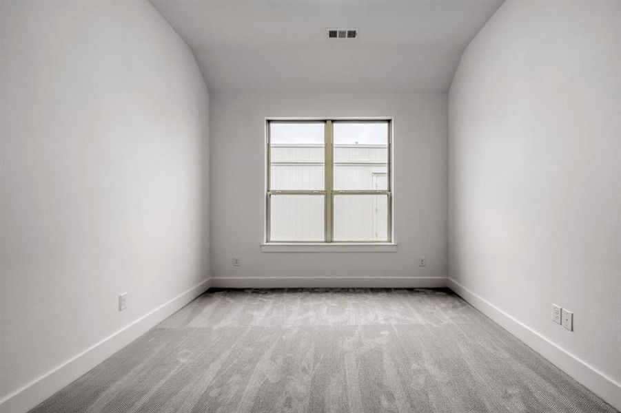 Empty room featuring light carpet and baseboards