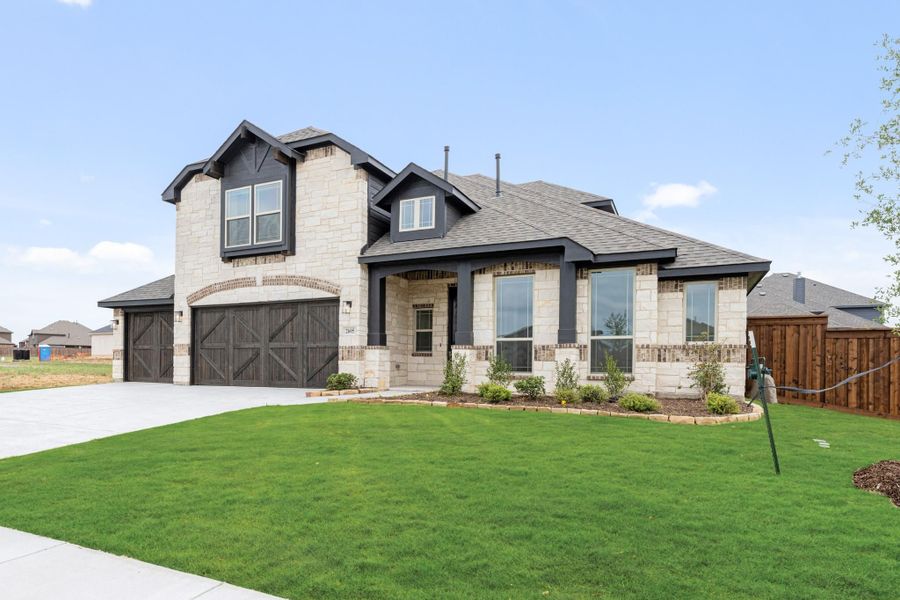Two-story home with stone and brick exterior, three-car garage, and manicured front lawn Two-story home with stone and brick exterior, three-car garage, and manicured front lawn