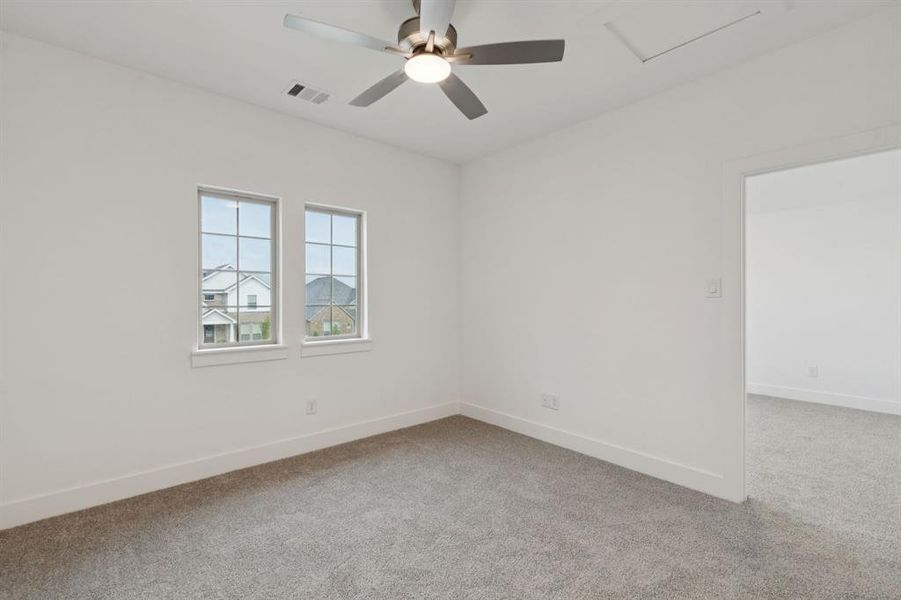 Unfurnished room featuring carpet floors, a ceiling fan, and attic access Unfurnished room featuring carpet floors, a ceiling fan, and attic access