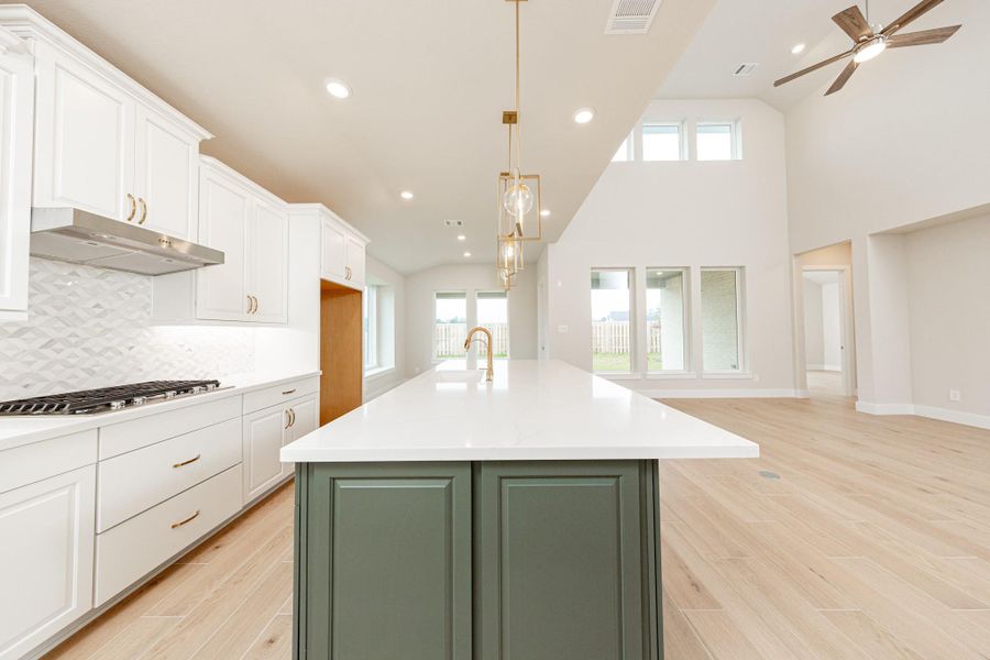 The kitchen includes Whirlpool stainless steel appliances: 30" 5-burner gas cooktop, coordinating built-in stainless steel microwave, oven wall unit, and dishwasher suggesting a professional and polished space.