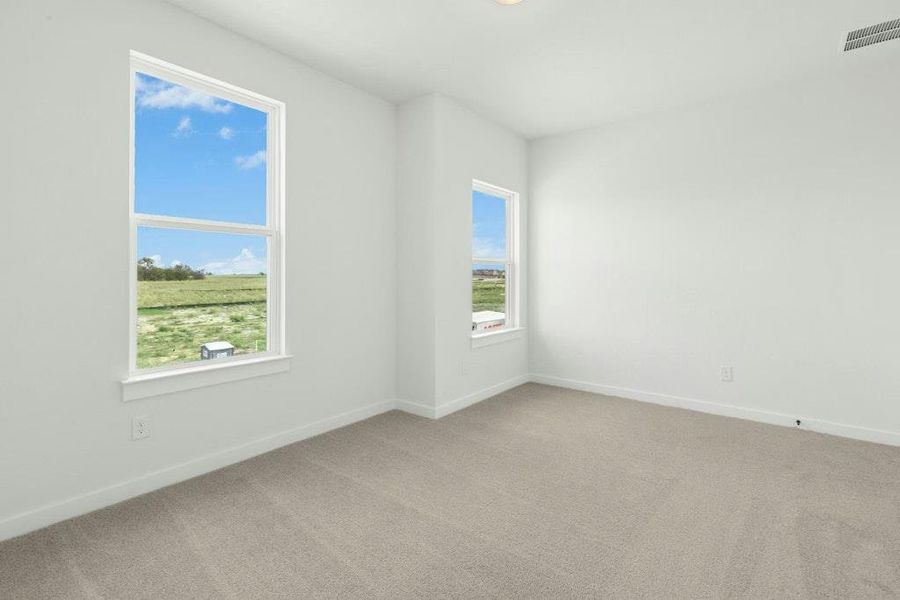 Empty room featuring light colored carpet and baseboards