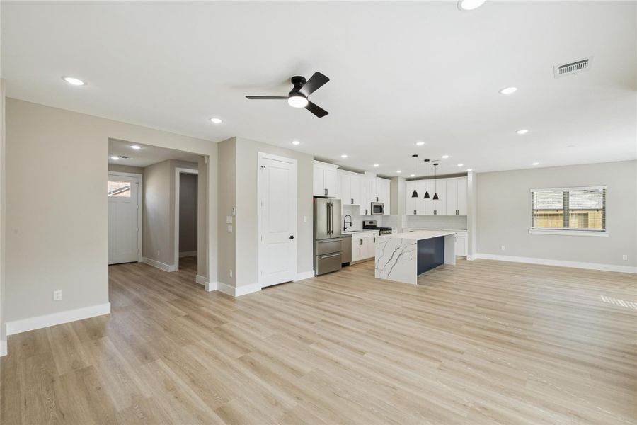 Spacious and inviting family room with open layout, seamlessly connecting to the modern kitchen—perfect for gatherings and relaxation.