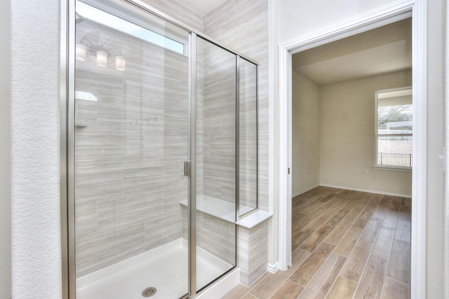 Full bathroom with a shower stall and wood tiled floor