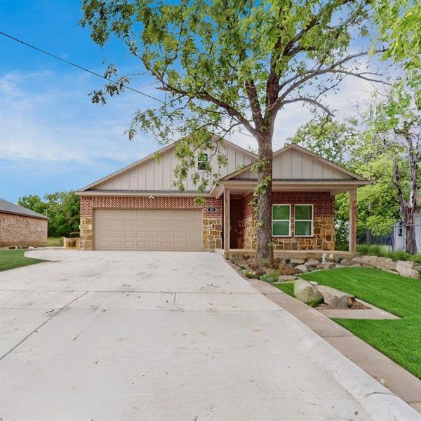 View of front of property featuring a garage, a front yard, and a porch