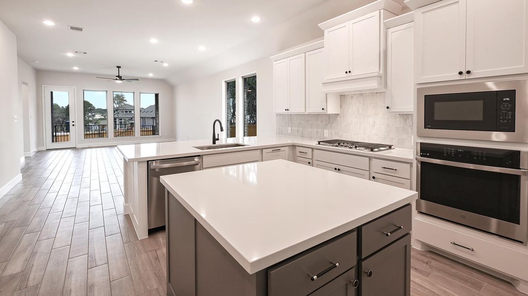 Kitchen with a center island, appliances with stainless steel finishes, recessed lighting, a peninsula, and light wood-type flooring