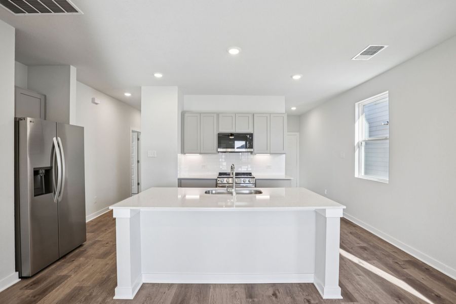 A kitchen with white cabinets.