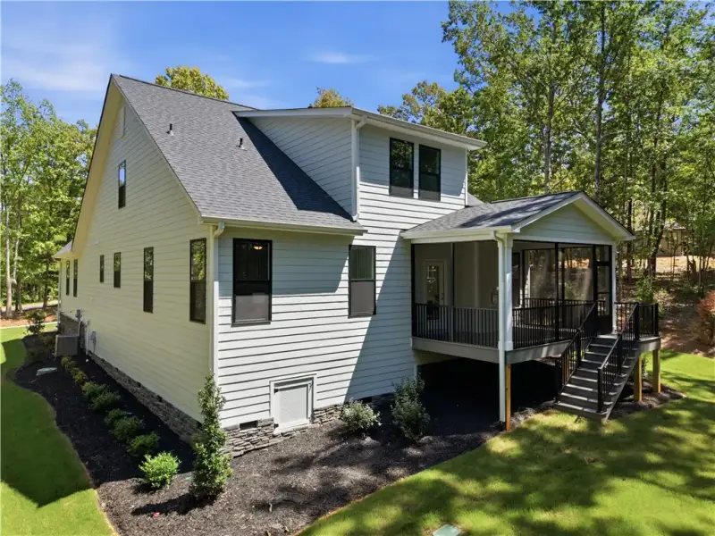 A screened porch extends from the rear facade, nes