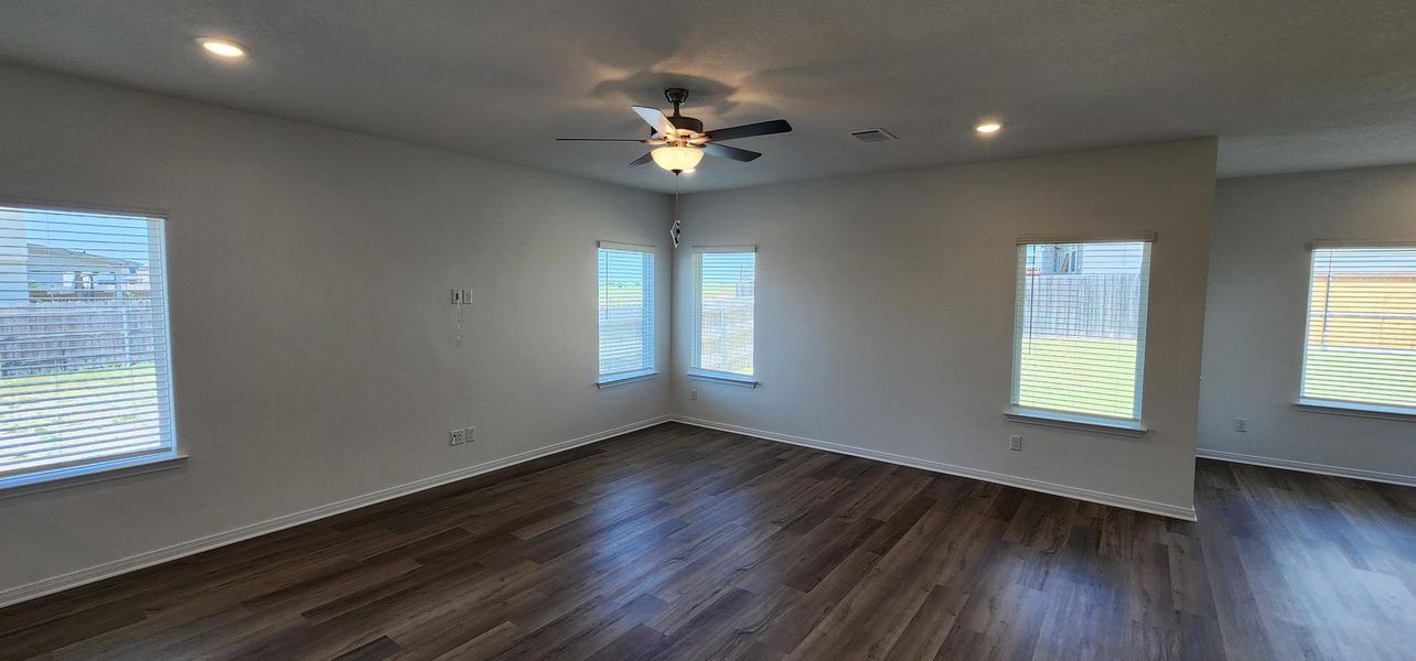 A well-lit living area features rich hardwood flooring and a contemporary ceiling fan with integrated lighting. A well-lit living area features rich hardwood flooring and a contemporary ceiling fan with integrated lighting.