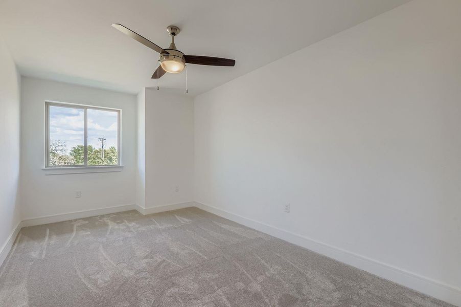Spare room with light colored carpet and ceiling fan