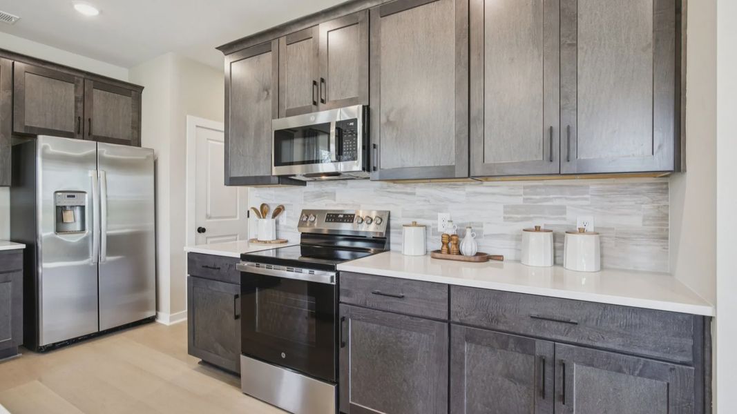 Kitchen with quartz countertops and dark cabinetry