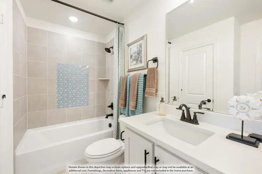 Bathroom with tiled tub-shower combo, white vanity with single sink, and large mirror