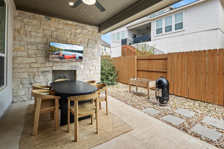 View of patio with outdoor dining area, ceiling fan, and fence