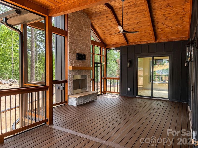 Expansive screened porch with vaulted wood ceiling and wood burning fireplace