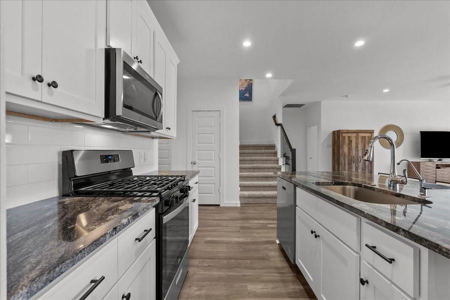 Chef’s eat-in island kitchen boasts stainless steel appliances, 42” cabinets with crown molding, lengthy countertops, breakfast bar seating, and a spacious pantry.