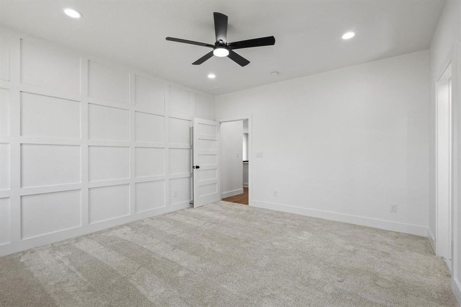 Carpeted empty room featuring ceiling fan