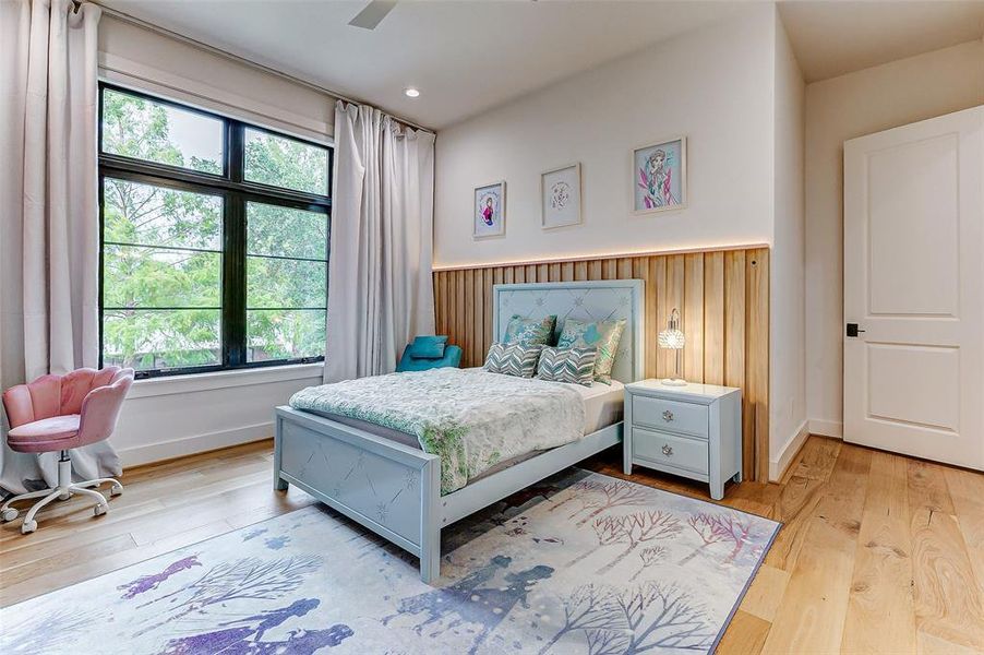 Bright and cozy bedroom featuring a large window with a  scenic view, a large walk-in closet, and an adjoining bathroom. Ideal for a peaceful retreat.