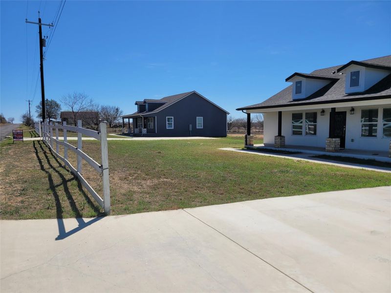 View of grassy yard featuring a porch