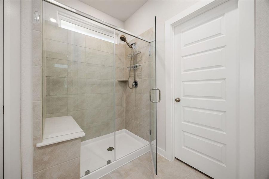 This additional view of the spacious walk-in shower with tile surround and seating, perfect for soaking after a long day.