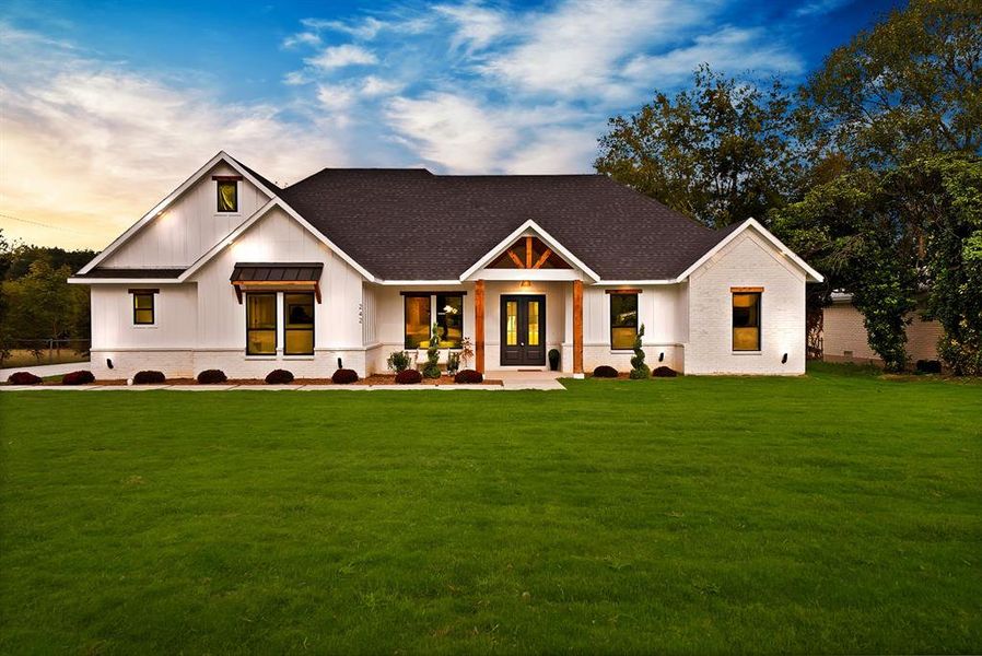 Modern inspired farmhouse with board and batten siding, a shingled roof, and a lawn Modern inspired farmhouse with board and batten siding, a shingled roof, and a lawn
