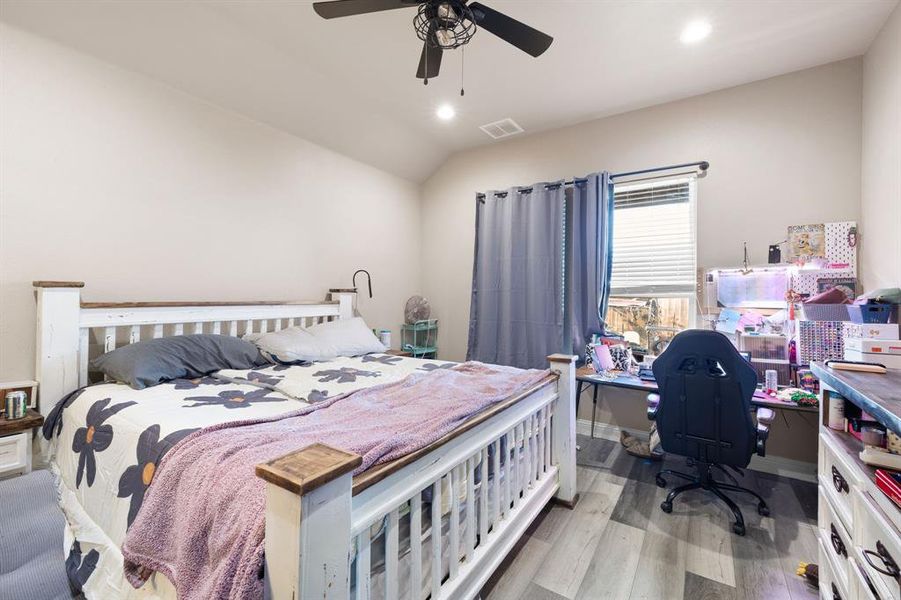 Bedroom featuring ceiling fan, lofted ceiling, and light hardwood / wood-style flooring