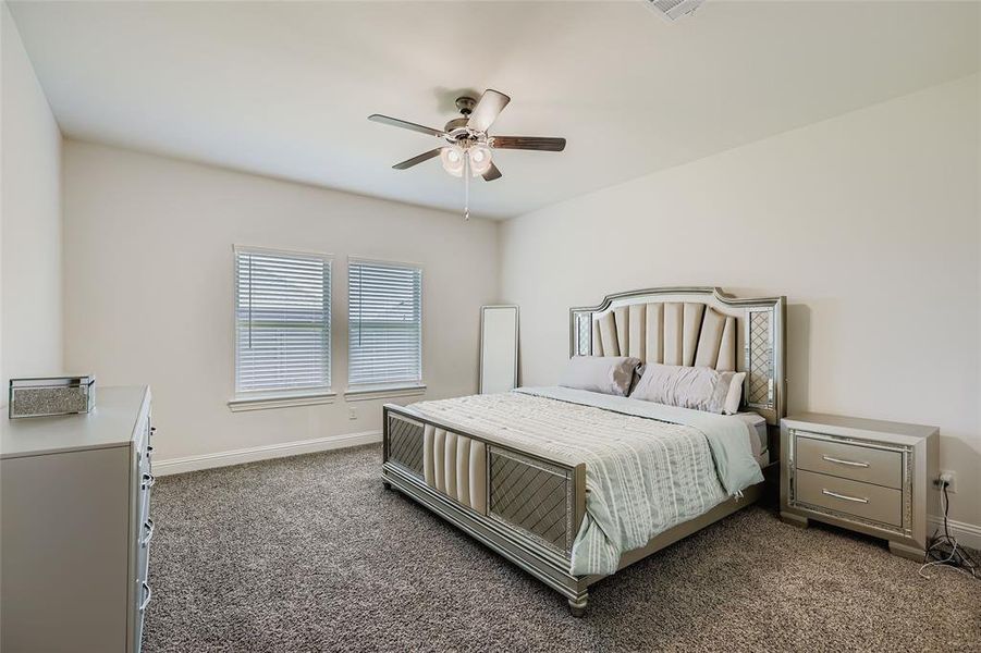 Carpeted bedroom with baseboards and ceiling fan