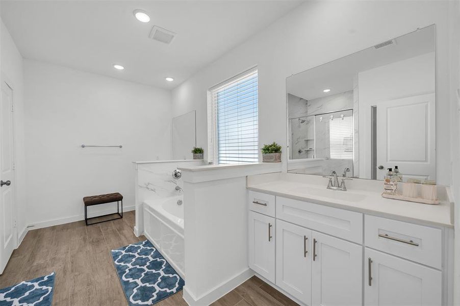 Bathroom featuring vanity, hardwood / wood-style floors, and shower with separate bathtub