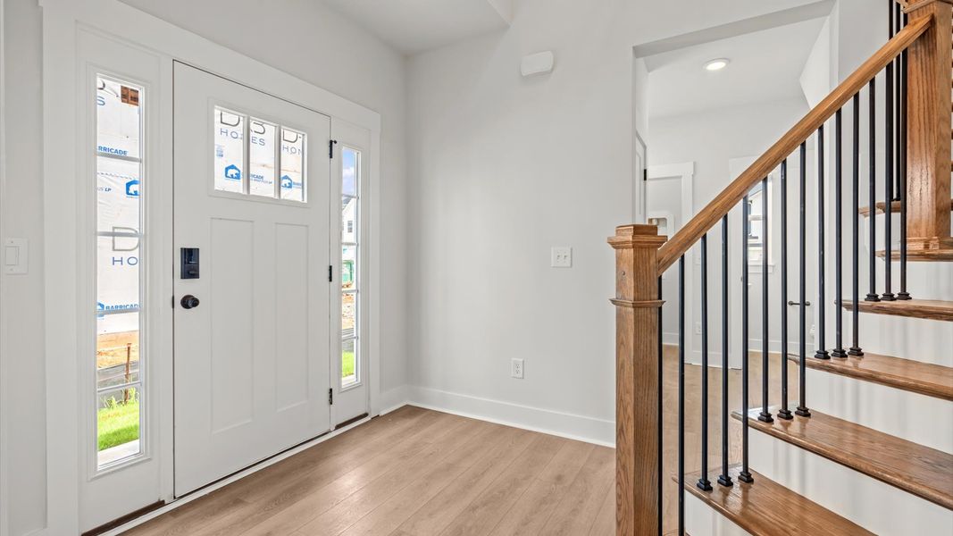 Highly functional foyer with hardwood flooring that flows seamlessly into living spaces