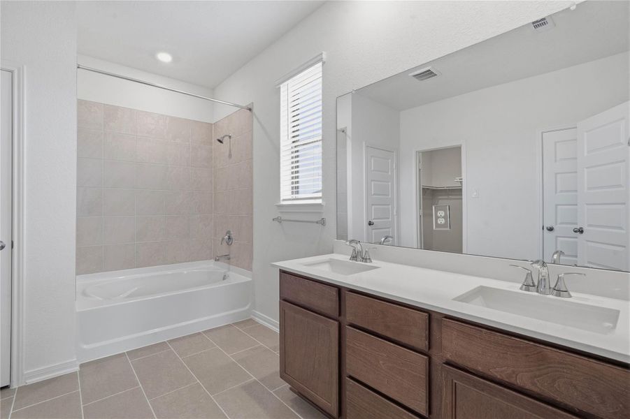 This stunningly updated primary bathroom is truly move-in ready! It features stained cabinetry with light countertops, dual sinks, a large mirror, high ceilings, custom paint, tub/shower combination with tile surround, and sleek modern finishes throughout. This stunningly updated primary bathroom is truly move-in ready! It features stained cabinetry with light countertops, dual sinks, a large mirror, high ceilings, custom paint, tub/shower combination with tile surround, and sleek modern finishes throughout.