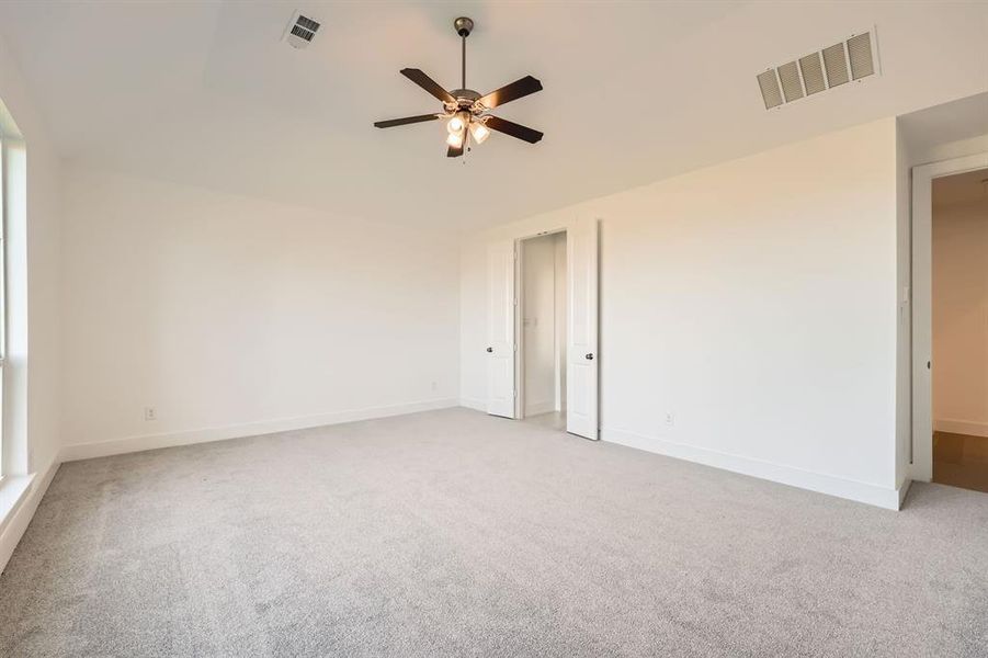 Carpeted spare room featuring ceiling fan