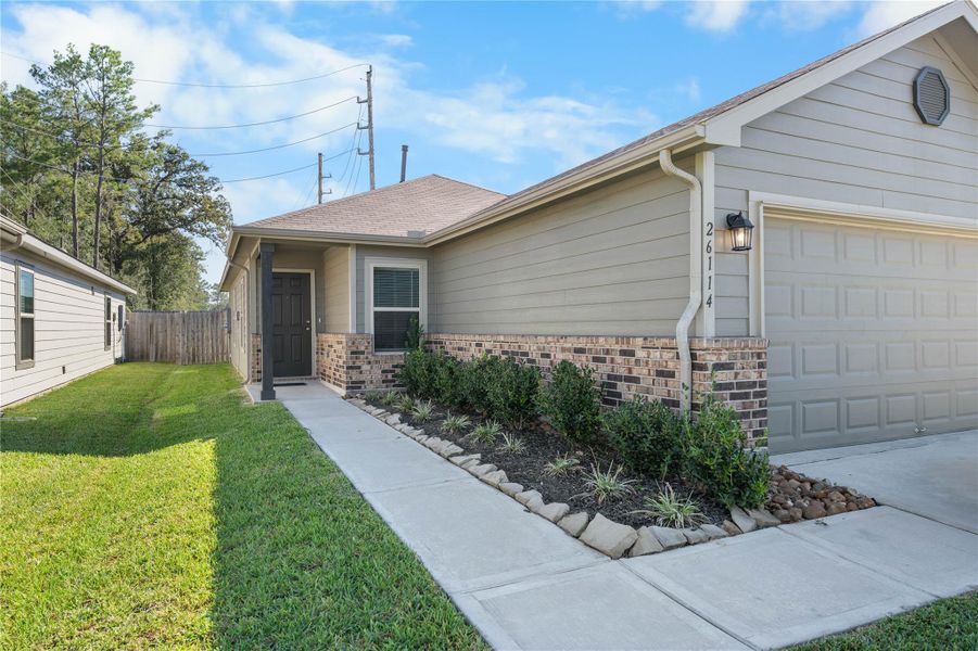 Covered front entry with brick accents and landscaping. Covered front entry with brick accents and landscaping.