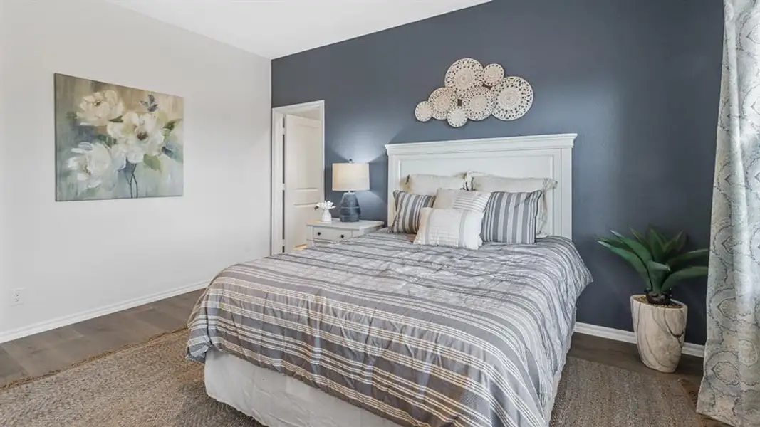 Bedroom with dark wood-type flooring and baseboards